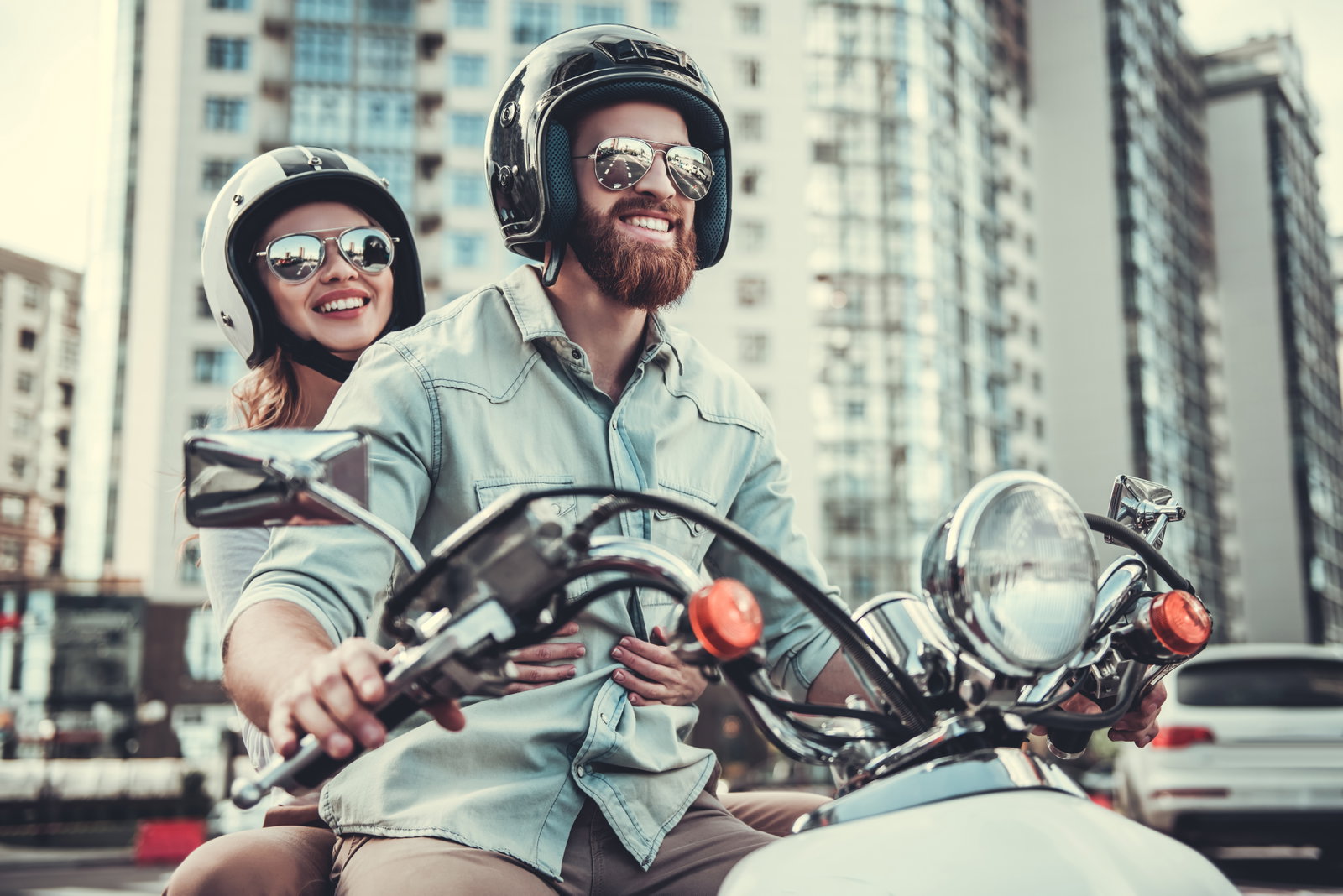 Zu sehen sind ein Mann und eine Frau auf einem Motorrad mit Pilotenbrillen.